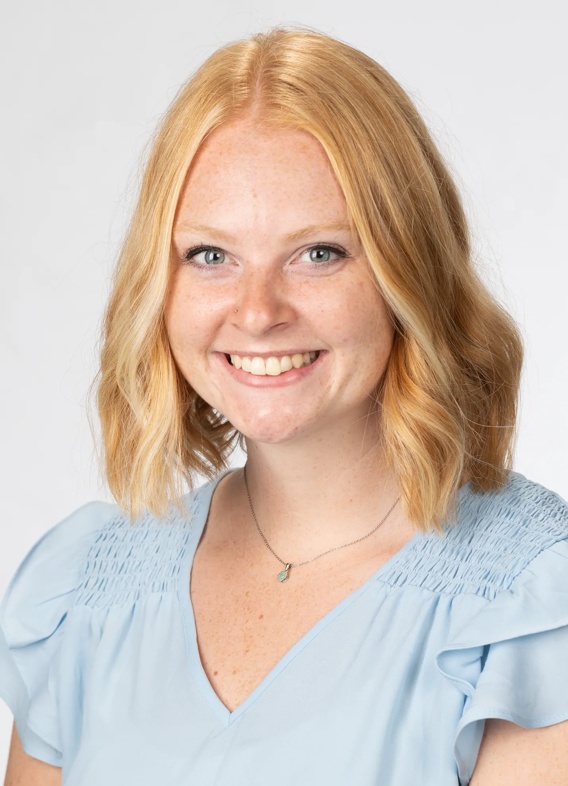 Portrait of Claire Gwilt, woman with short blonde hair and a blue shirt.