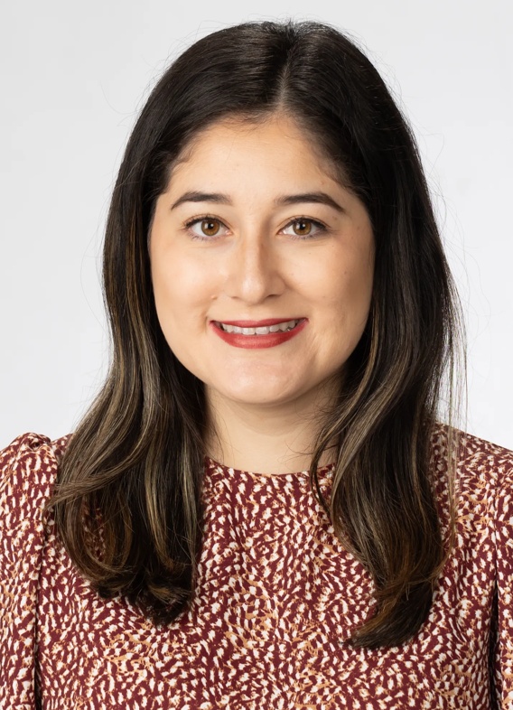 Portrait of Dianne Mancheno Alvarez, woman with long brown hair and a red shirt.