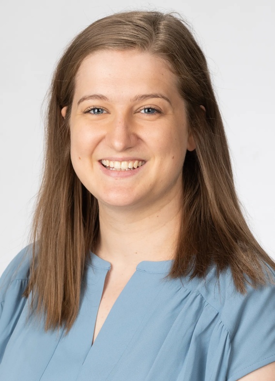 Portrait of Emma Schwendeman, woman with long brown hair and a blue shirt.