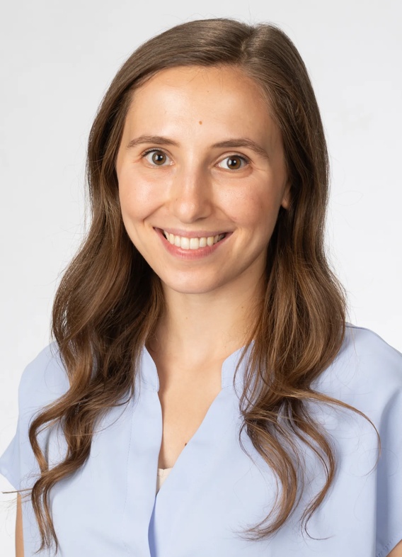 Portrait of Evelyn Gartstein, woman with long brown hair and a blue shirt.