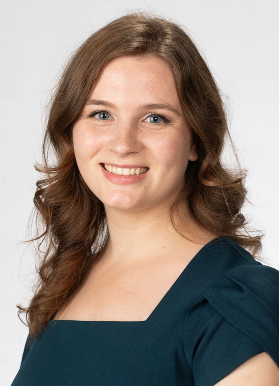 Portrait of Kelly Spatorico, woman with long brown hair and a green shirt.