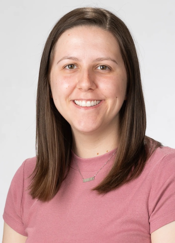 Portrait of Laura Shine, woman with long brown hair and a pink shirt.