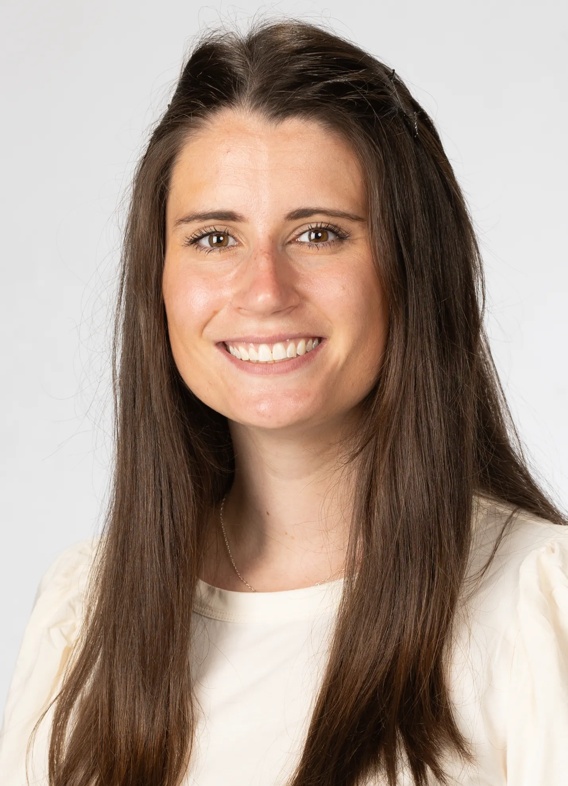 Portrait of Madelyn Green, woman with long brown hair and a white shirt.