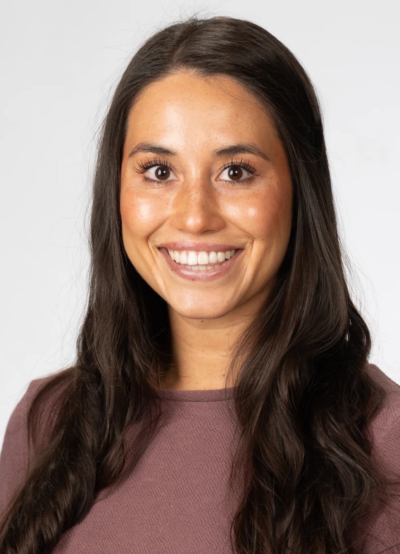 Portrait of Marcella Orozco, woman with long brown hair and a pink shirt.