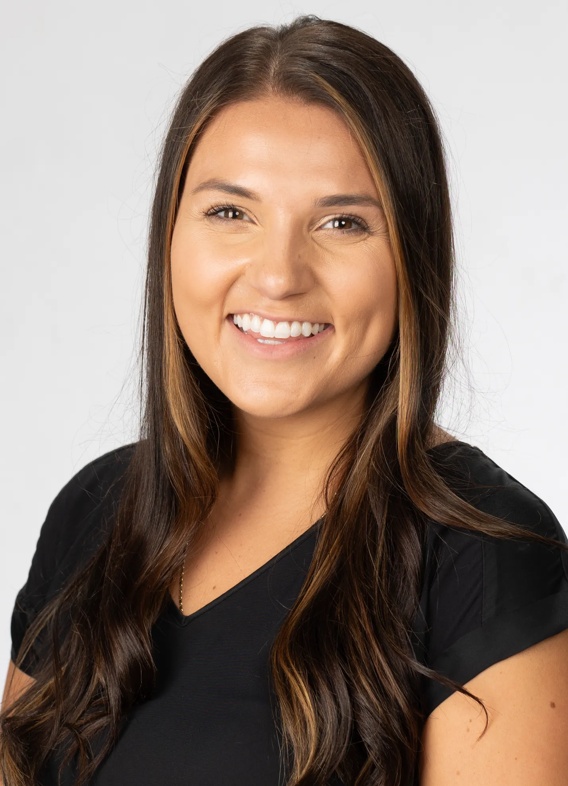 Portrait of Maria Riley, woman with long brown hair and a black shirt.