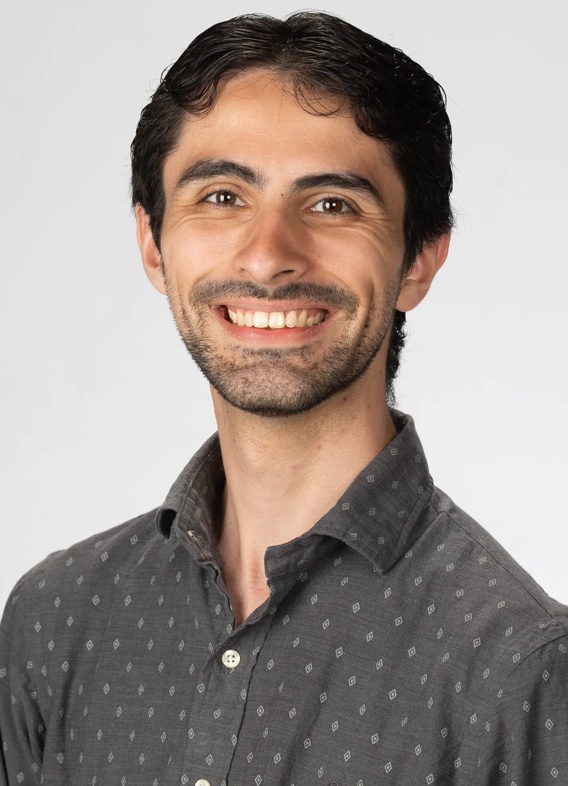 Portrait of Neil Sykes, man with short black hair and a grey shirt.