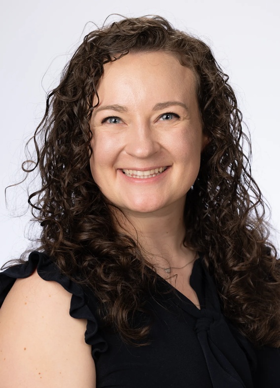 Portrait of Julia Neri, woman with long brown hair and a black shirt.