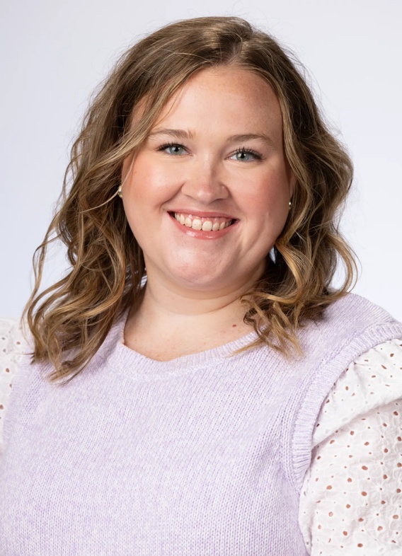 Portrait of Leah Shephard, woman with short brown hair and a purple shirt.