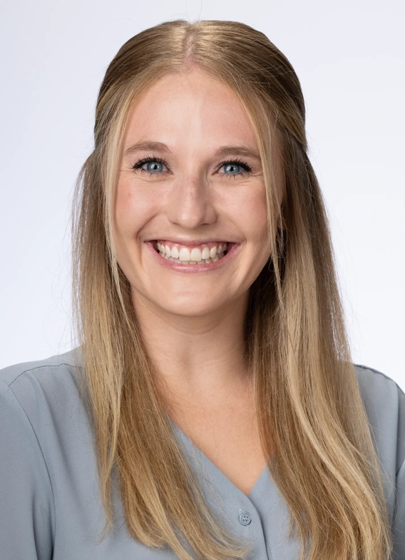 Portrait of Mackenzie Blackburn, woman with long blonde hair and a grey shirt.