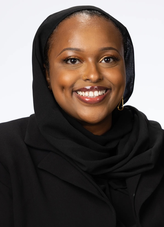 Portrait of Maryam Hassan, woman with a black head scarf and black shirt