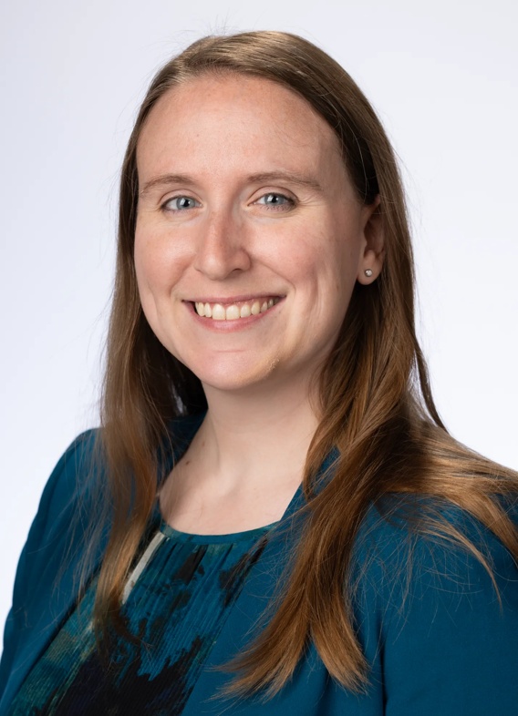 Portrait of Michelle Drews, woman with long brown hair and a dark blue-green shirt.