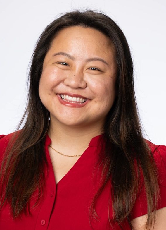 Portrait of Nicole Ashley Hao, woman with long brown hair and a red shirt.