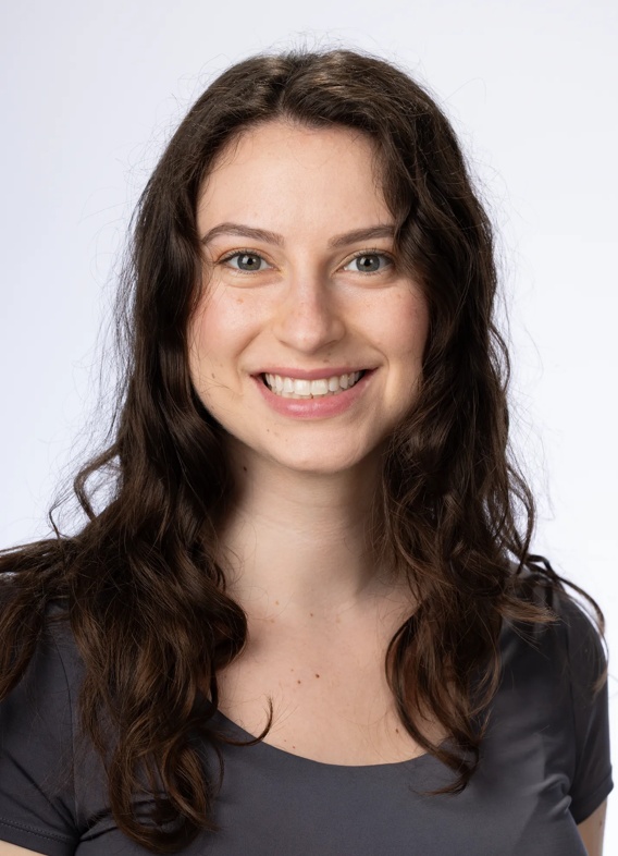 Portrait of Rebecca Bruns, woman with long brown hair and a grey shirt.