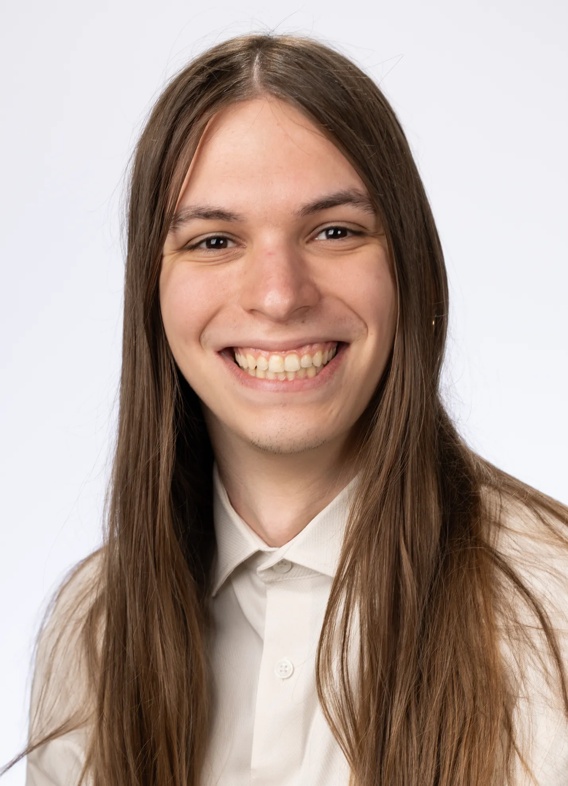 Portrait of Steven Hart, man with long brown hair and a white shirt.