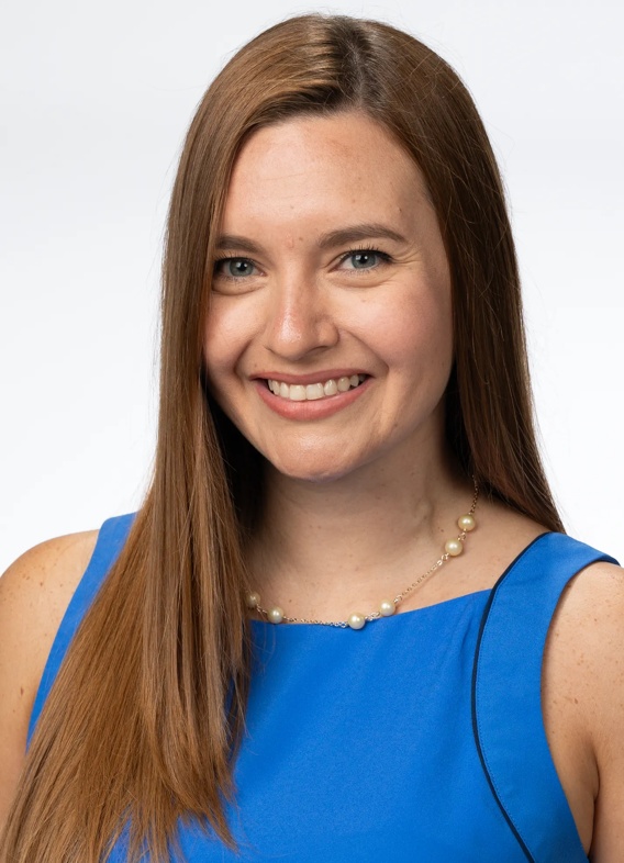 Portrait of Andrea Newman Molina, woman with long brown hair and a blue shirt.