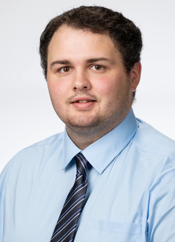 Portrait of Andrew Bixler, man with short brown hair and a light blue shirt and tie