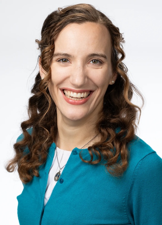 Portrait of Daly Trimble, woman with long brown hair and a blue-green shirt.