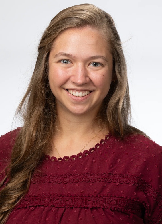 Portrait of Erin Bellingham, woman with blonde hair and a red shirt.