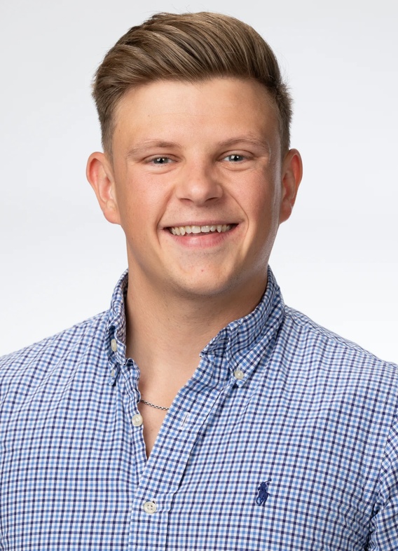 Portrait of Grafton Barnett, man with short blonde hair and a blue shirt.