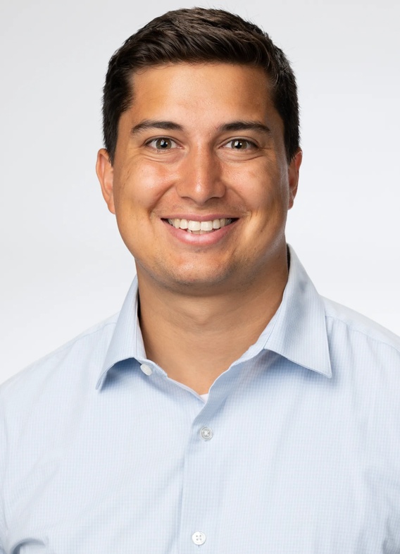 Portrait of Joshua Venegas, man with short black hair and a light blue shirt.