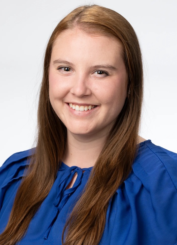 Portrait of Kendra Madaris, woman with long red hair and a blue shirt.