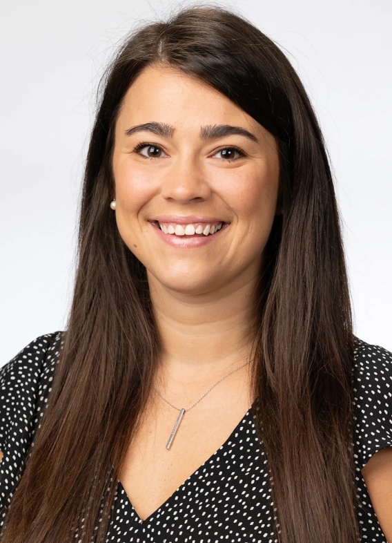 Portrait of Olivia-Marie Groves, woman with long brown hair and a black shirt.