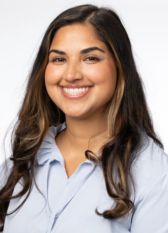 Portrait of Sasha Sharma, woman with long brown hair and a light blue shirt.