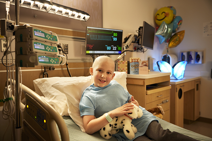 young boy leukemia patient with no hair in hospital bed