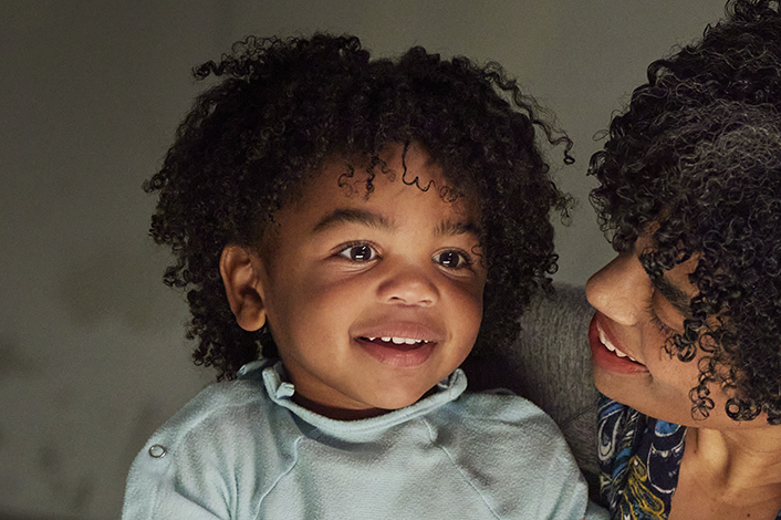 toddler smiling in mom's arms
