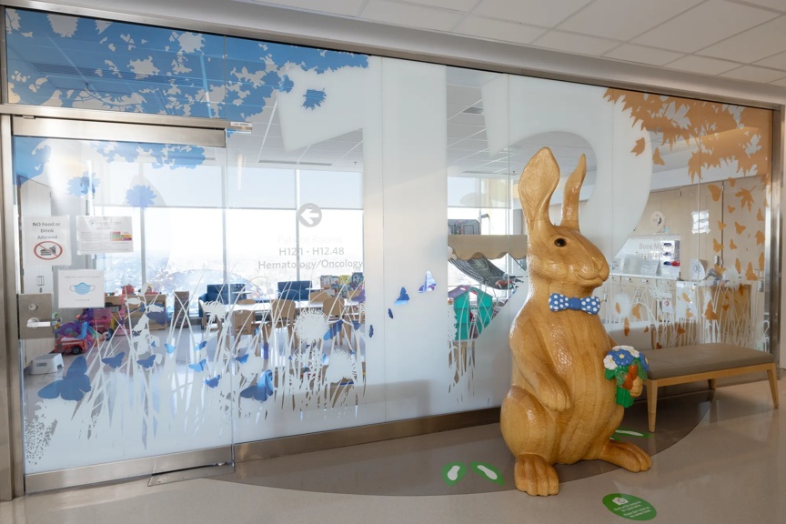 Entrance to Hematology/Oncology department featuring a wooden bunny statue and butterfly-themed glass decoration.