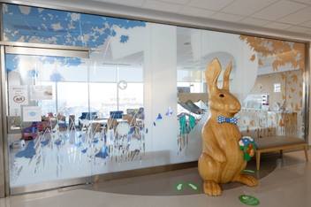 Entrance to Hematology/Oncology department featuring a wooden bunny statue and butterfly-themed glass decoration.