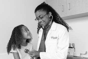 Female resident examining toddler boy