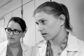 Two residents reviewing content displayed on a computer screen