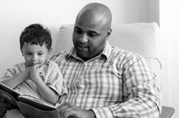 Father Reading to Young Boy in Hospital Room