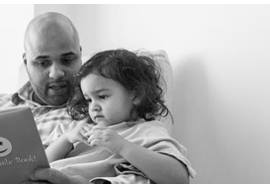 Dad reading to young girl in hospital room