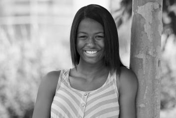 Teenage Girl Leaning on Tree Smiling