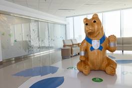Wooden bear sculpture in a hospital lobby, designed to create a welcoming environment for patients and visitors.