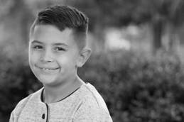 Child sitting outside of Nationwide Children's Hospital, smiling for the camera.