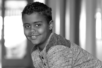 Young Boy Smiling in Hallway