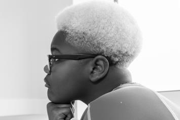 Profile of boy resting chin on knuckles