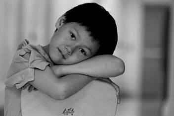 Young Boy Leaning on Chair in Hospital