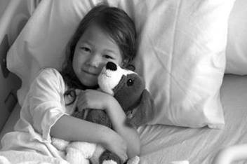 Young Girl in Hospital Bed with Stuffed Animal