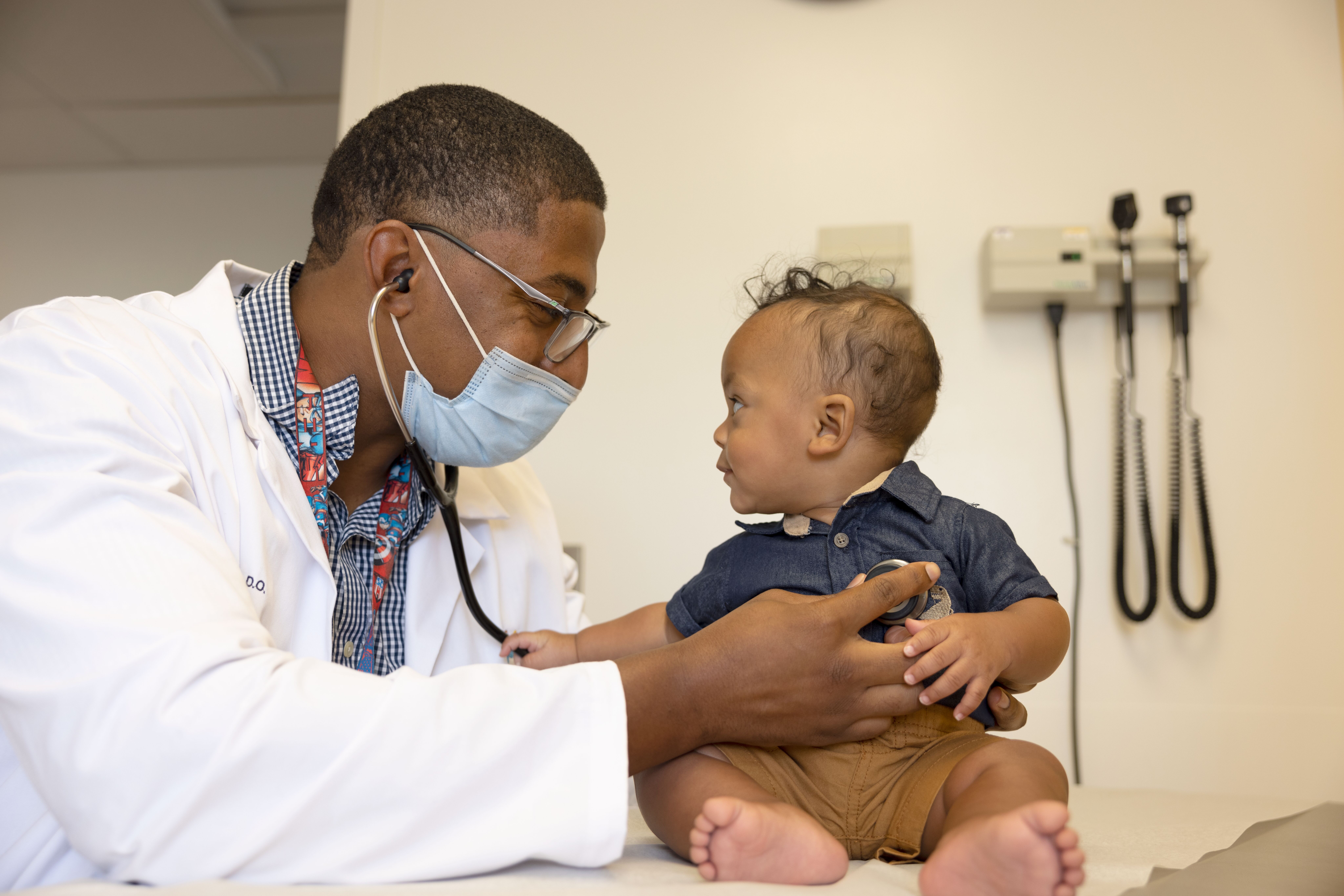 A healthcare provider examines a baby during a check-up in a clinical setting.