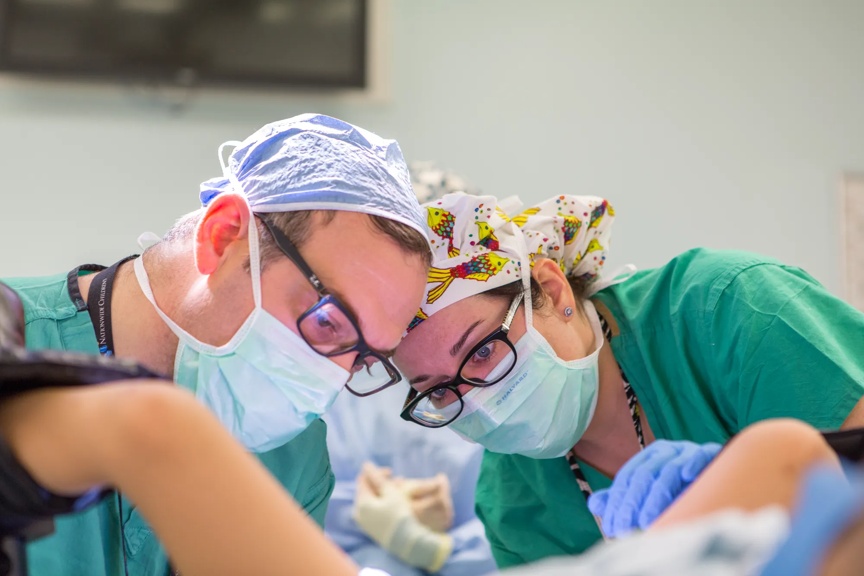 Two doctors performing a medical procedure.