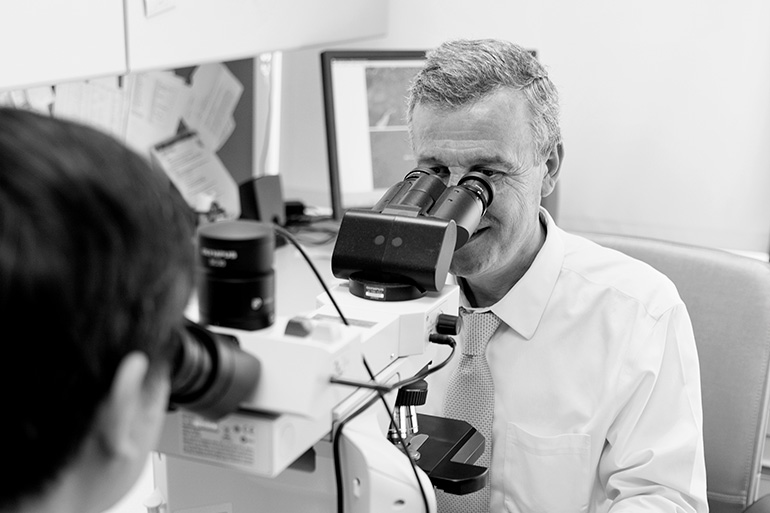 doc looking through microscope