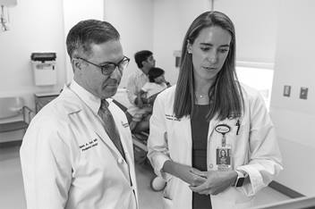 Two doctors looking down at computer