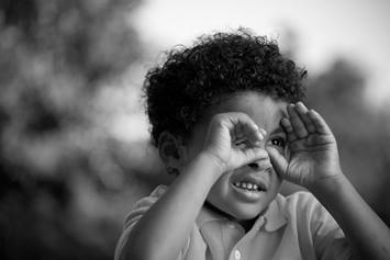 Boy Looking Through Hands