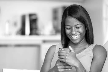Teenage Girl Smiling and Looking at Her Cell Phone