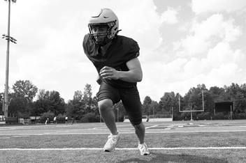 A football player gains momentum, running forward