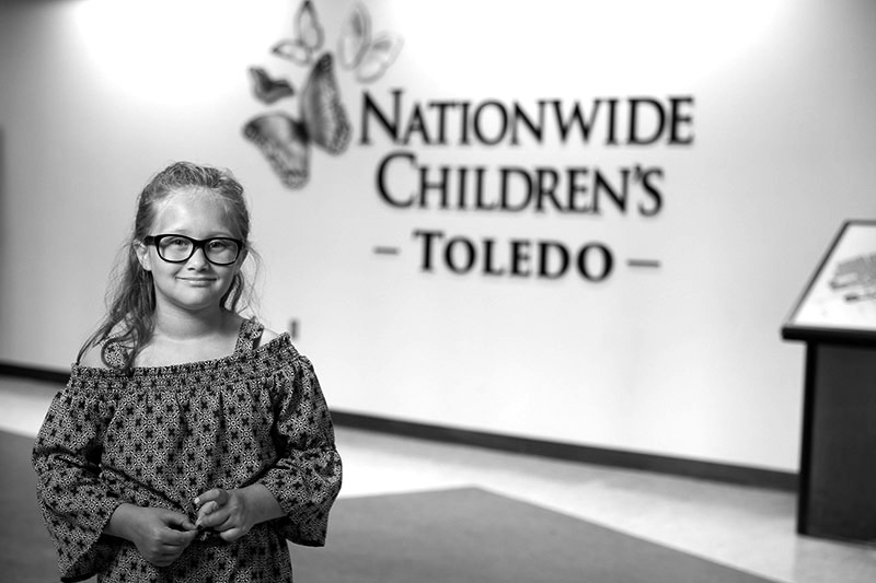 Patient standing in front of Nationwide Children's Hospital - Toledo sign